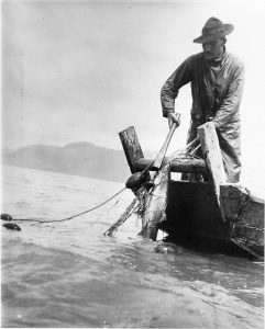 Suquamish fisherman catching salmon. Photo courtesy of Suquamish Museum Archives.